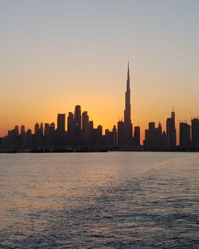 Dubai Burj Khalifa ve şehir silueti körfezden gün batımında